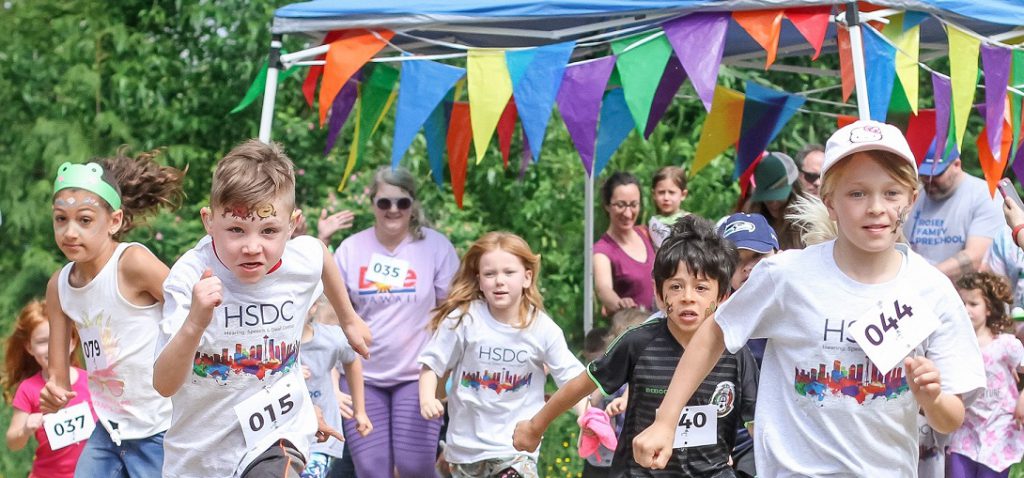 A photo from the 2018 Froggy Fun Run. Kids sprint from the starting line.