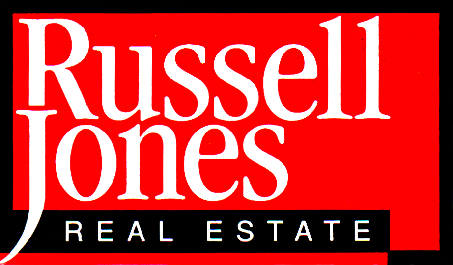 Russell Jones Real Estate logo. A red rectangle with a black border. Inside, the words Russell Jones are prominent in white. Underneath, inside the red box, are the words Real Estate inside a black bar underlining name above.